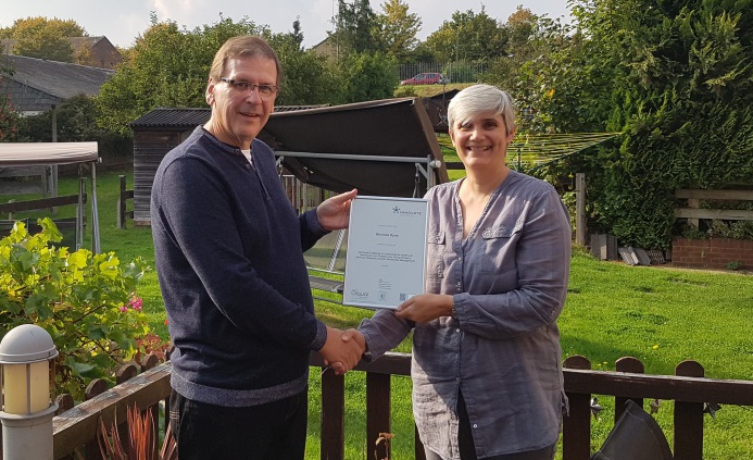 Diagrama Chief Operating Officer Derek Milliken presents Cabrini House residential manager Michelle Dyne with her certificate 
